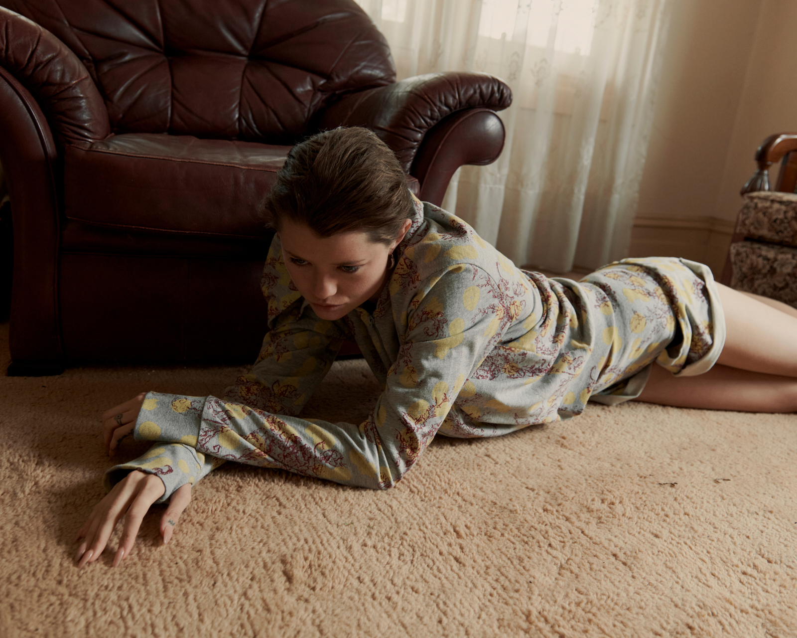 Model lying on vintage carpet in patterned shirt — editorial fashion photography