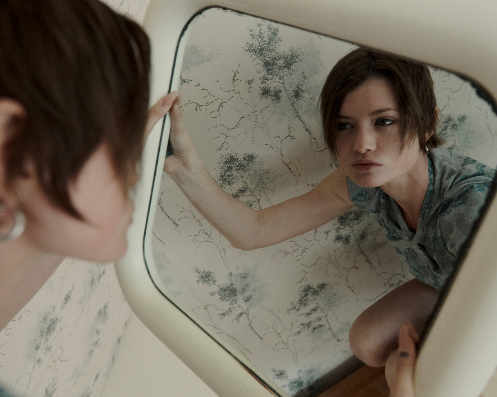Intimate portrait — model reflected in vintage bathroom mirror, editorial fashion